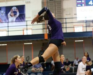 Volleyball player jumping to spike ball.