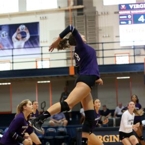 Volleyball player jumping to spike ball.