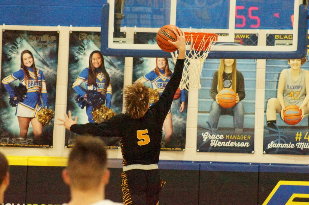 Player in black jersey attempts a basketball shot near the hoop.