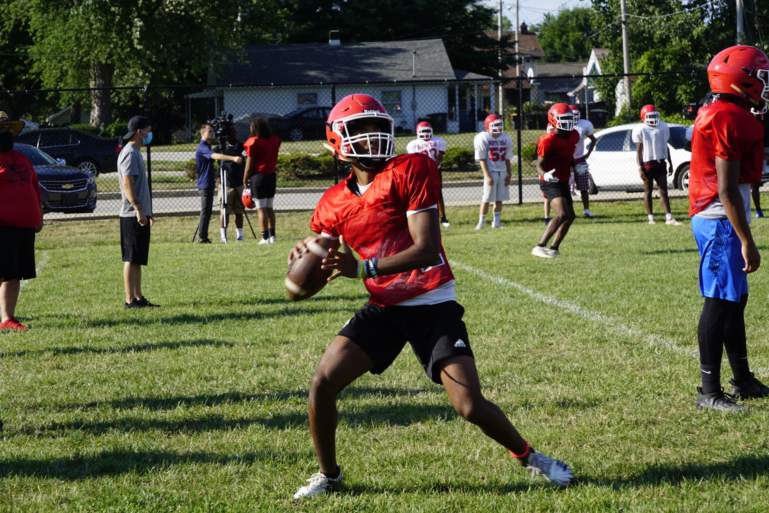 Young football player preparing to throw a pass during practice.