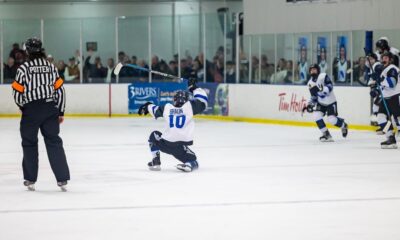 Ice hockey player celebrating on the rink after scoring a goal.