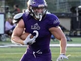 Football player in purple uniform running with the ball.