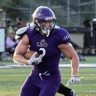 Football player in purple uniform running with the ball.