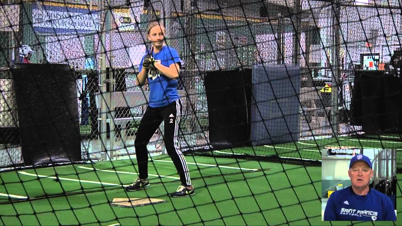 A man prepares to bat in an indoor cricket net.