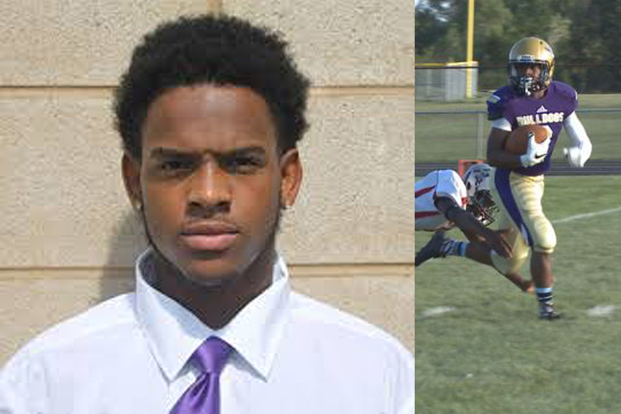 Young man in a white shirt with a purple tie standing outdoors.