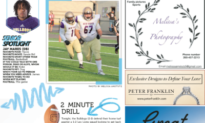 Two young football players running on a field during practice.