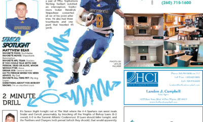 High school football player in blue and yellow uniform carrying the ball.