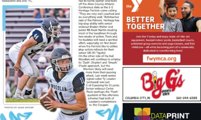 A football player catching a pass during a game, with teammates and crowd in the background.