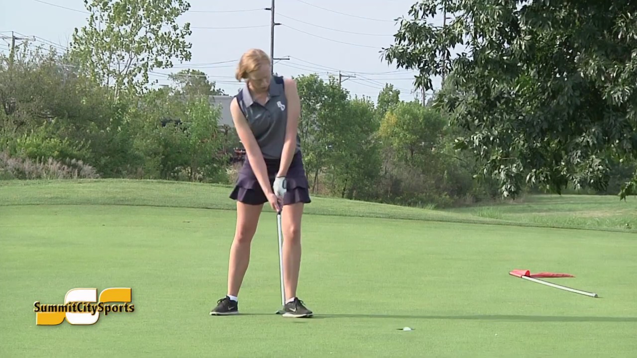 Woman preparing to putt on a golf green.